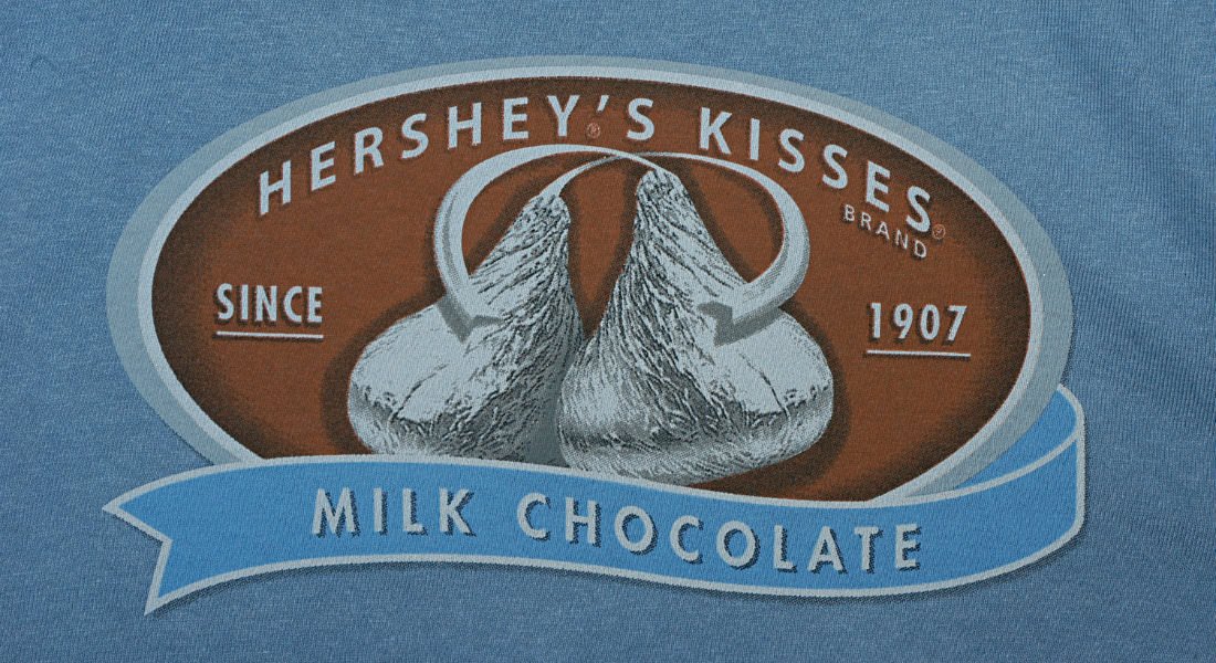 A blue sign advertising silver Hershey's Kisses.