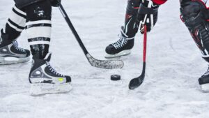 close up of hockey puck and players on ice