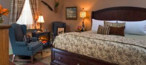 king bed and high-back chair in mallard guest room at 1825 inn