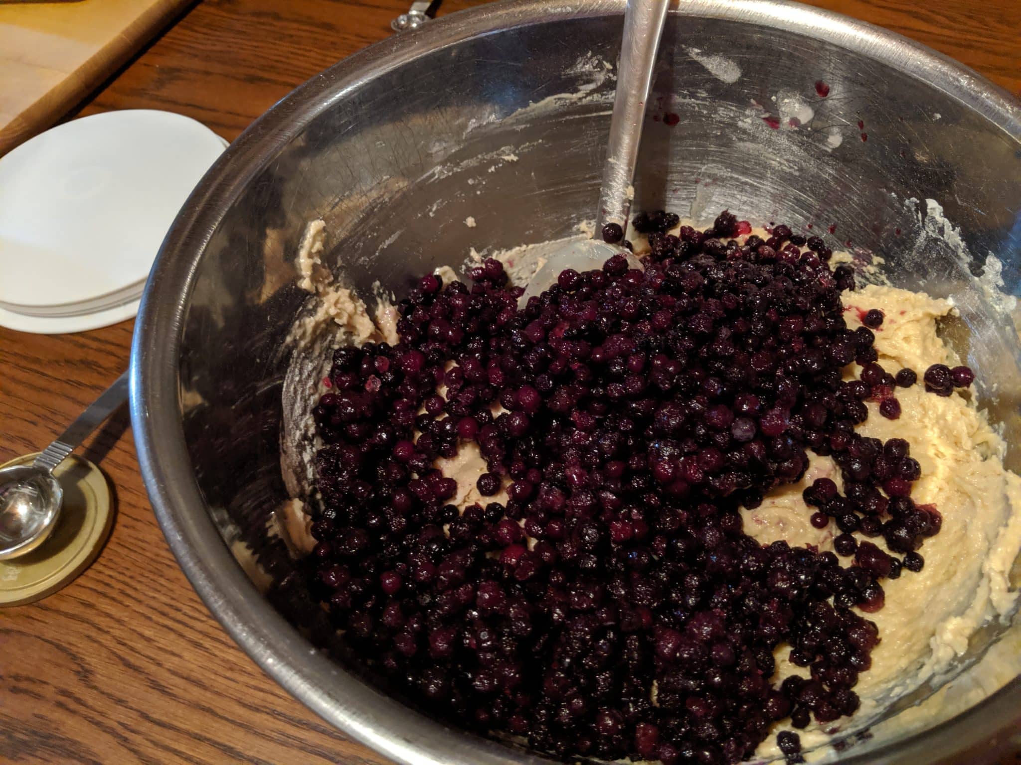 muffin batter in bowl with blueberries just added
