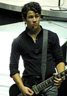 Color photo of Nick Jonas playing guitar