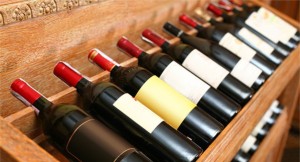 Wine bottles resting on wooden shelves